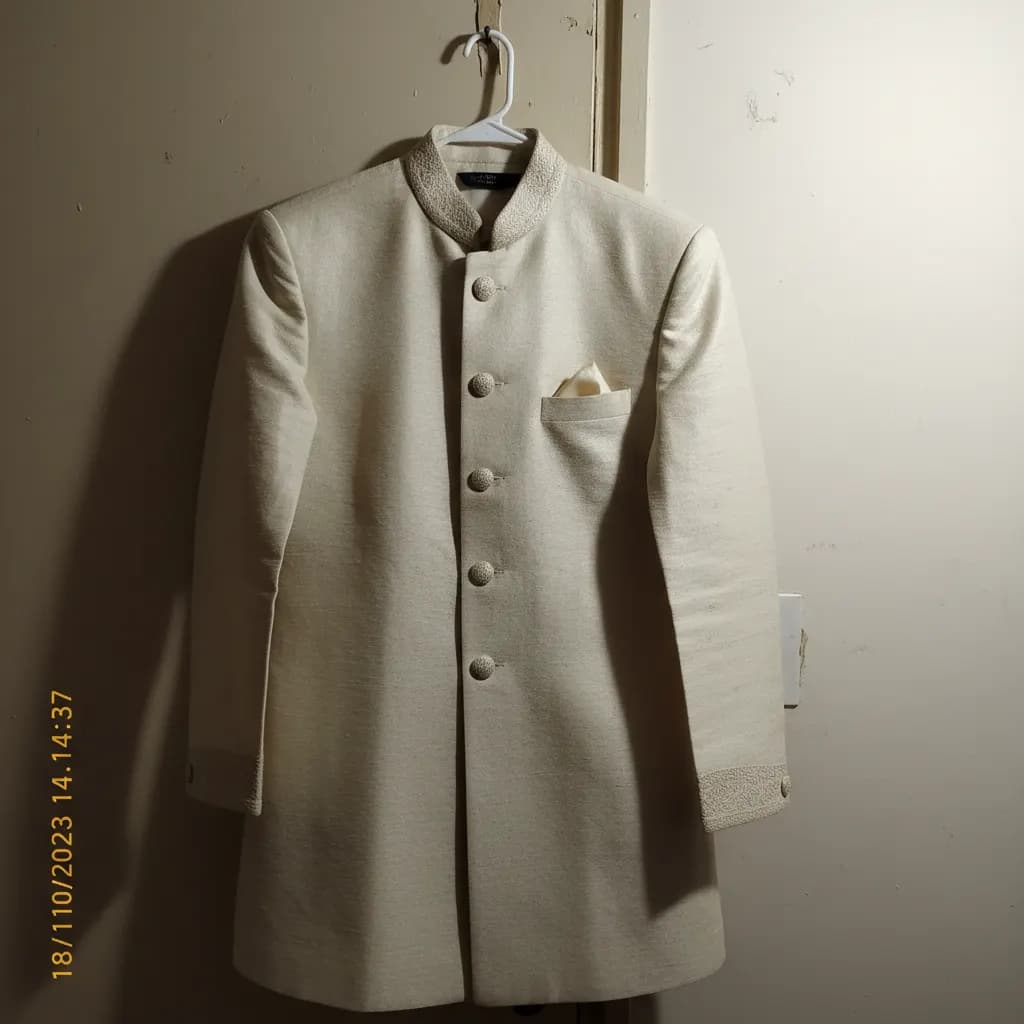 Flat-lay sherwani on plain background